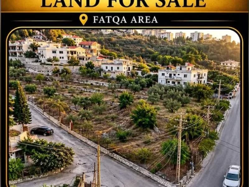 Terraced building plot in Fatqa with road access and village houses beyond