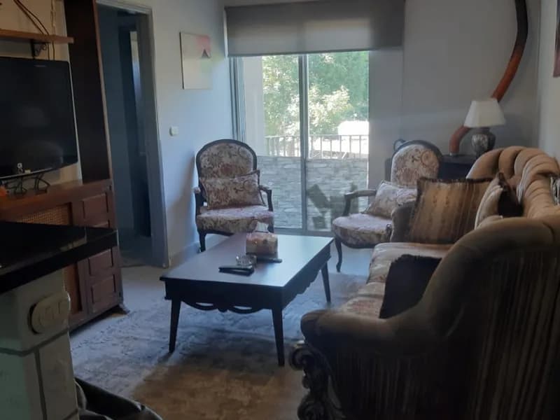 Salon of the Faraya chalet with a chandelier, television and balcony doors