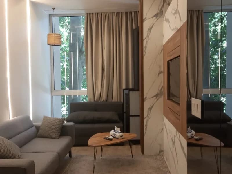 Living area of the Faraya studio chalet with a marble partition and mirrored wall